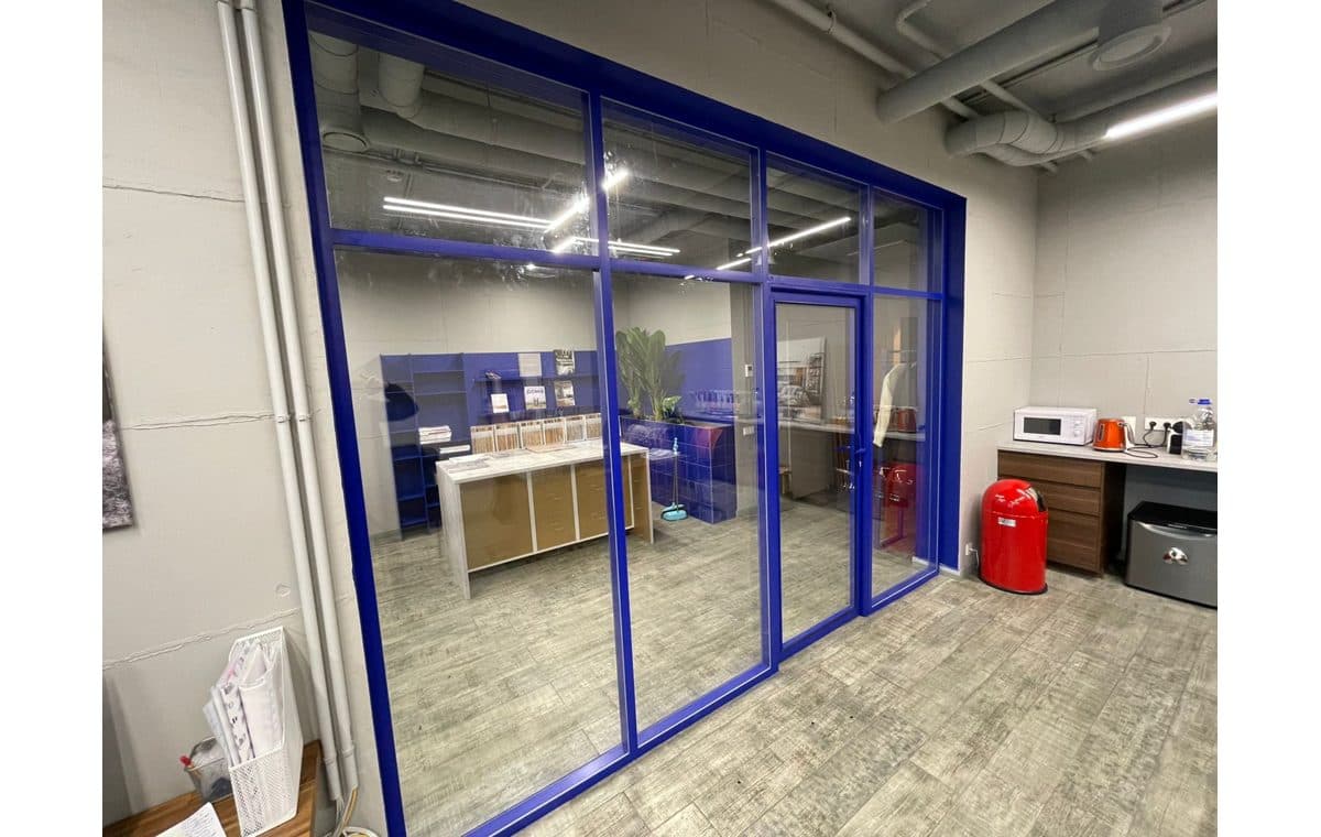 Монтажник стеклянных перегородок на объекте в офисе