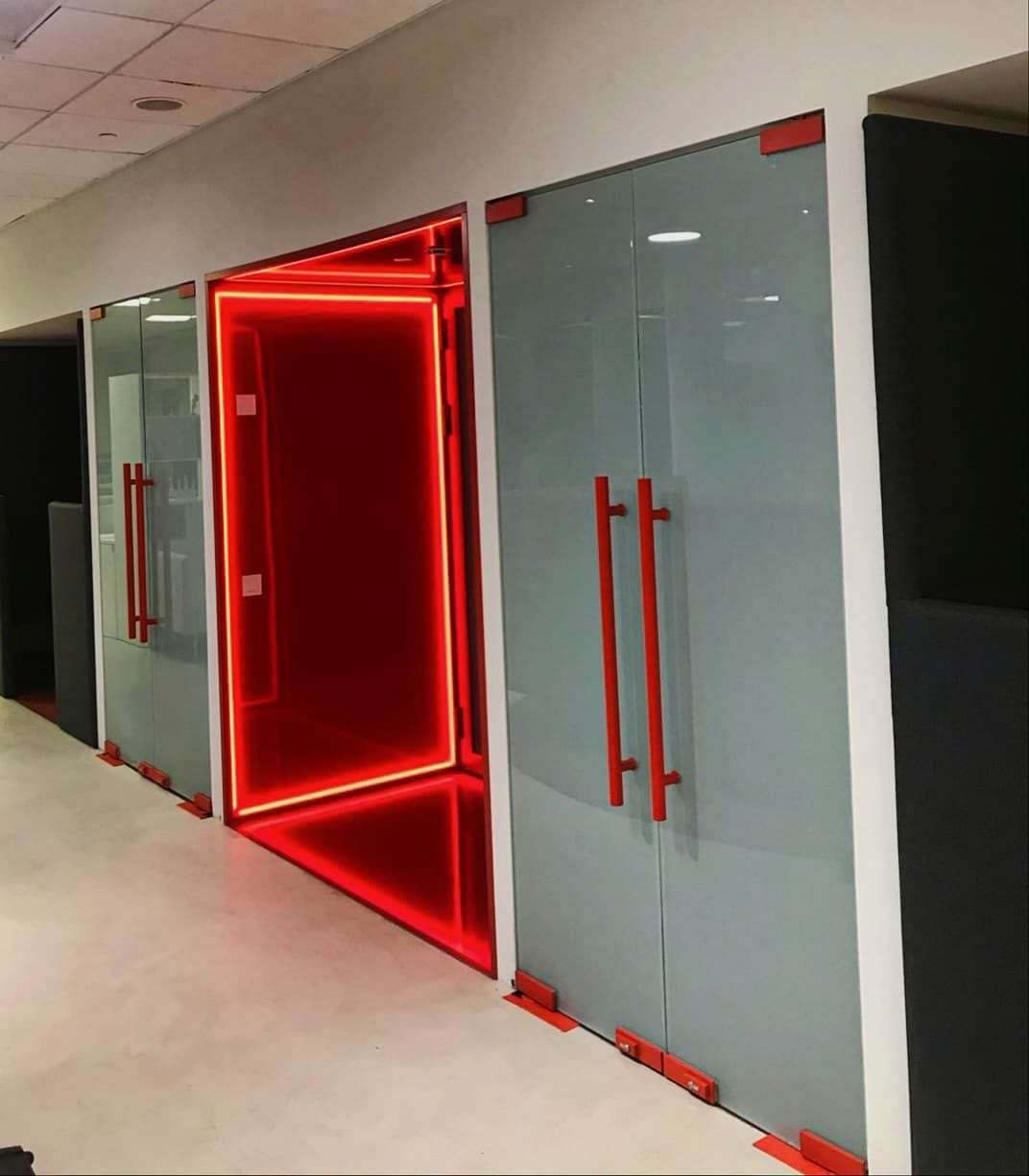 Цельностеклянные перегородки, двери с матовым полотном, красными ручками и красными петлями