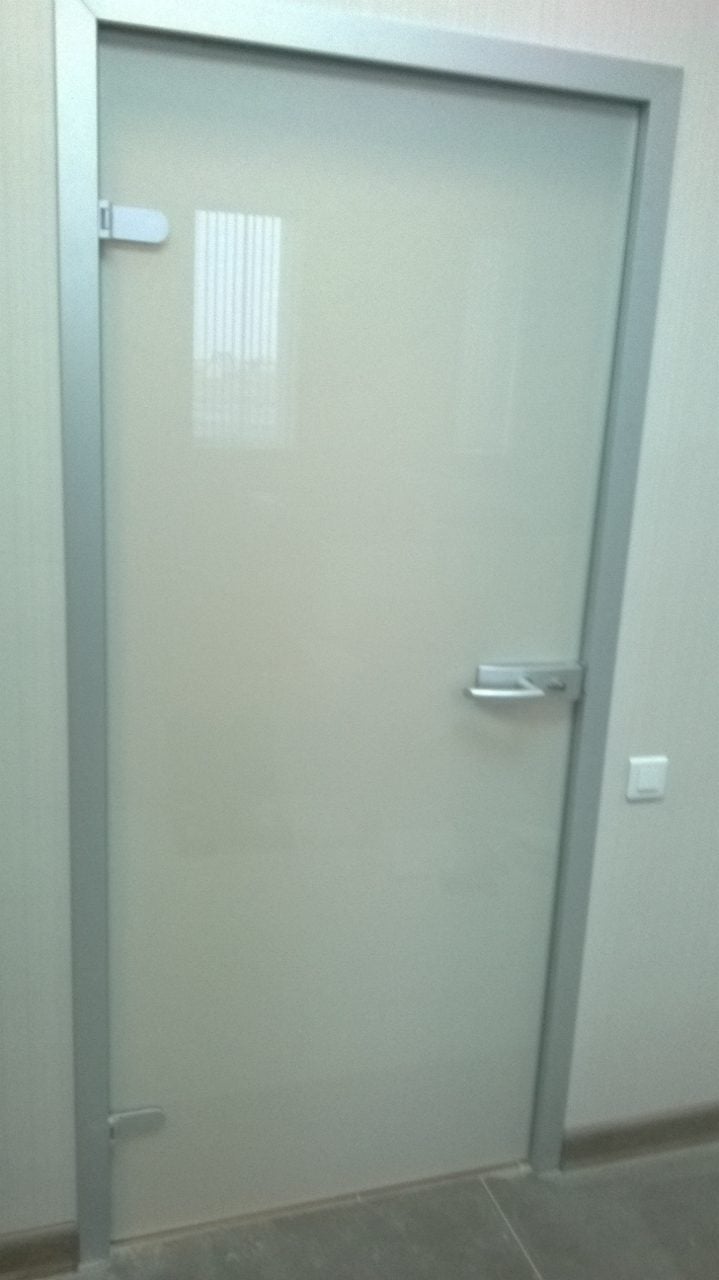 Матовое дверное полотно в серой коробке: петли и ручка стоят на стекле