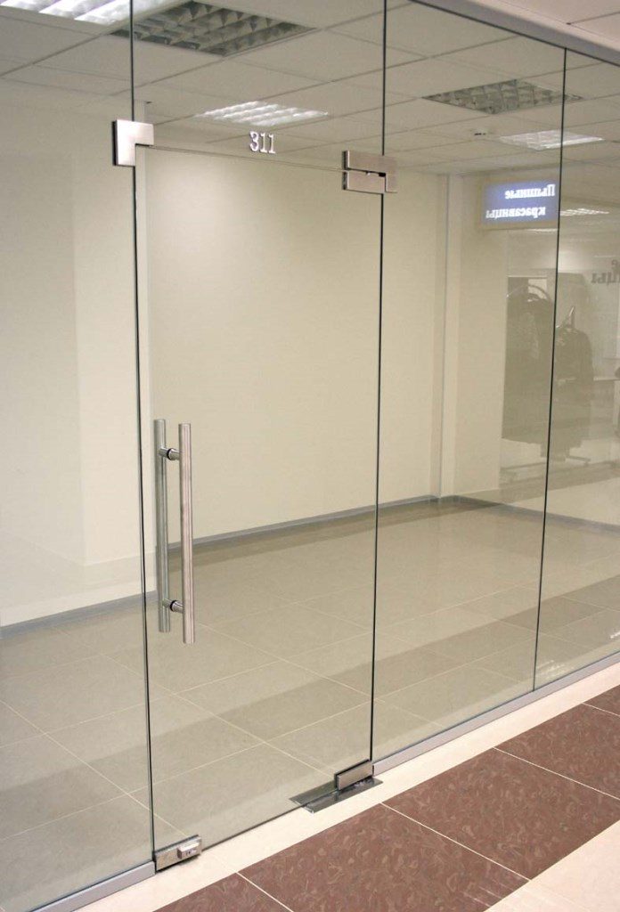 Цельностеклянная перегородка с маятниковой дверью и фурнитурой из нержавеющей стали в бизнес-центре