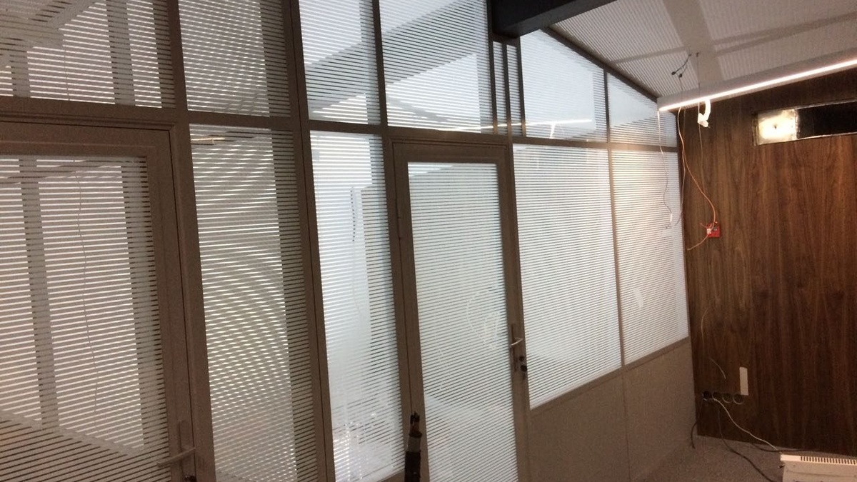 Алюминиевый профиль перегородки обходит потолочную балку в офисе — инженерная готовность