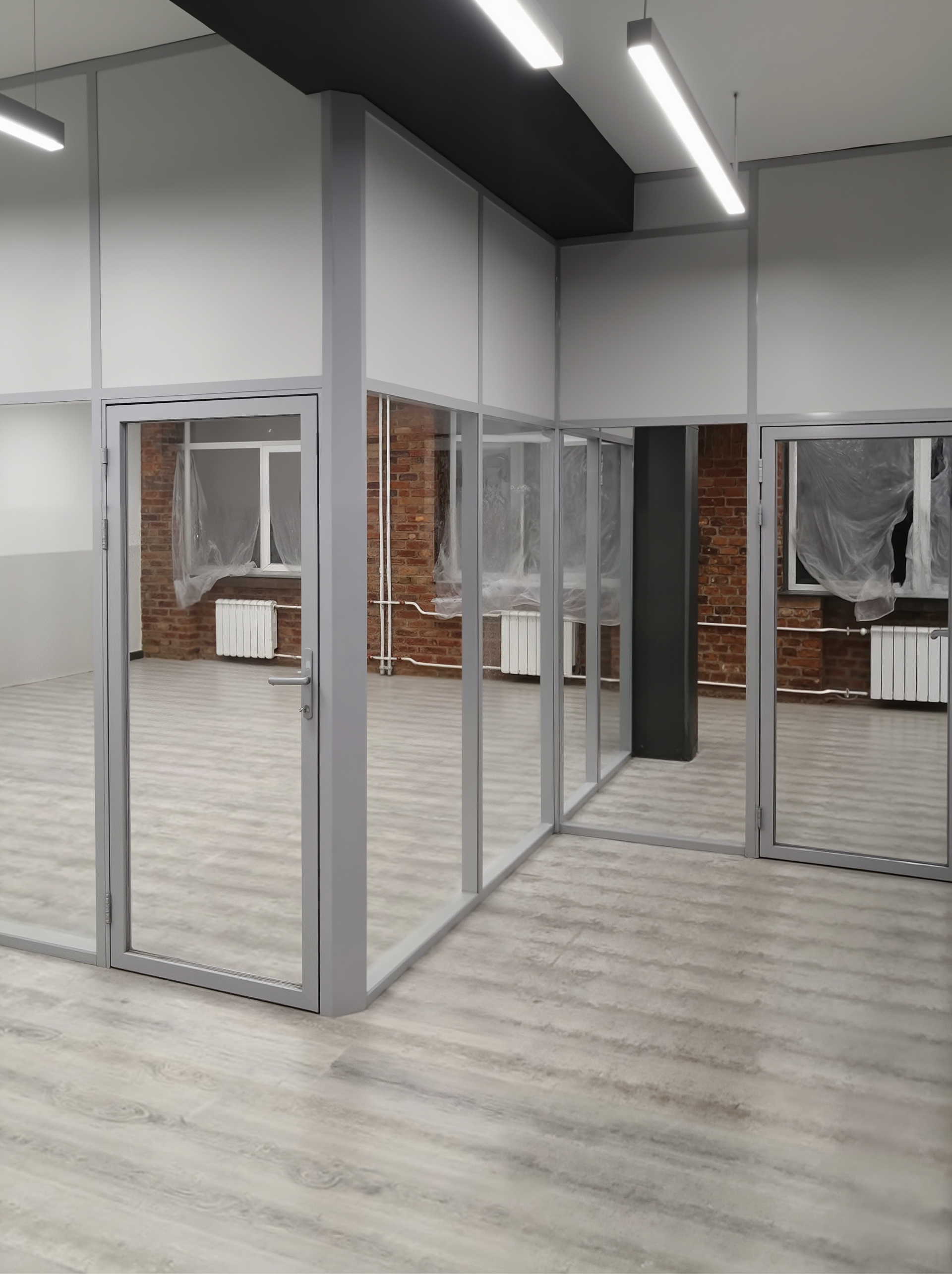 Стационарные стеклянные перегородки в лофт-офисе с кирпичными стенами