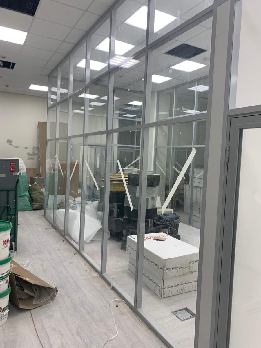 Фасадный ряд стеклянных секций на алюминиевом каркасе вдоль стены