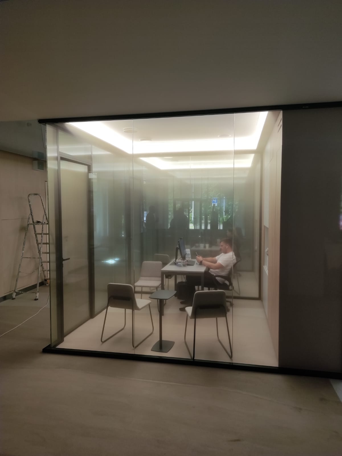 Цельностеклянная переговорная — человек работает за звукоизолированным стеклом